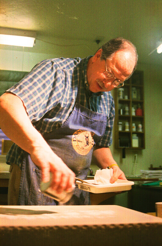 Talc is sprinkled over the stone's surface to dry the wax images.