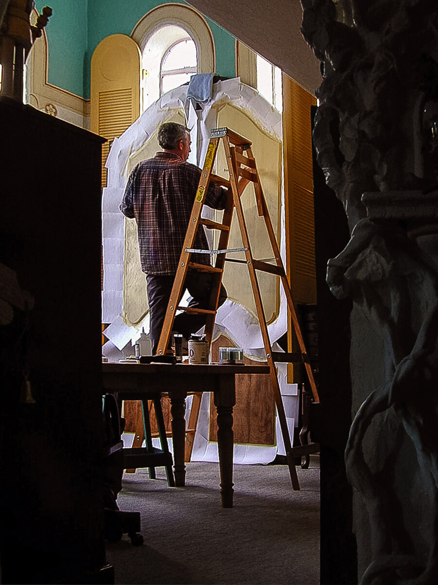 Having sanded the raised panels to removed their finish, Al applies tinted Gesso to serve as the gro...