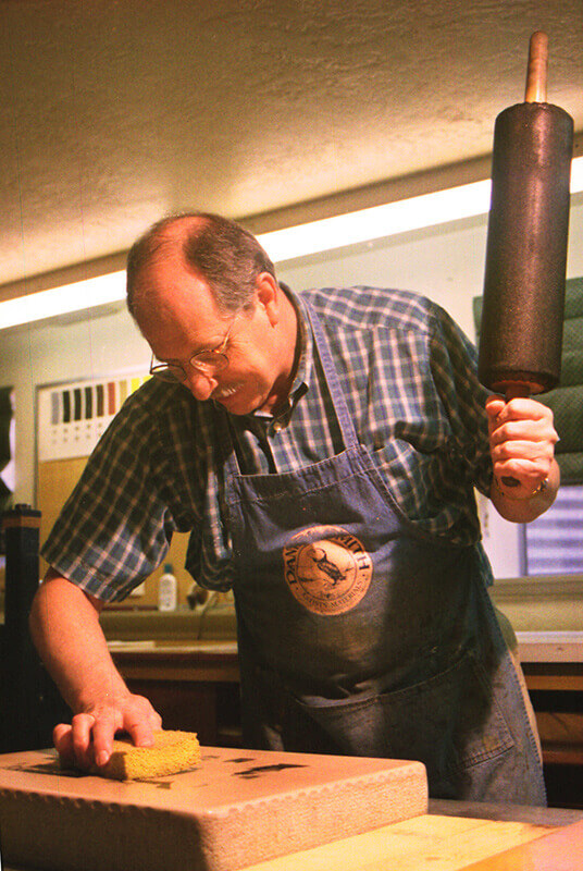 The stone is sponged with water preparatory to inking the images.