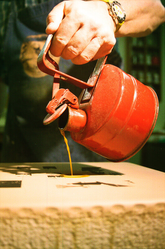 Lithotine is applied to the stone's surface to remove the wax used to draw the images.